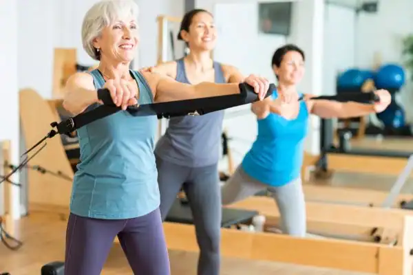 older woman doing weight training Addlestone and resistance in the gym to tone upper arms