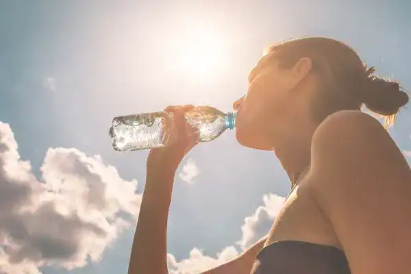 Hydration: The Secret Ingredient for a Toned Stomach and Enhanced Fitness 3 Image of woman drinking water to hydrate Addlestone after run.